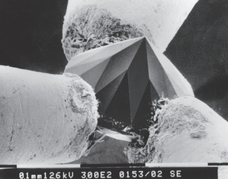 Photo au microscope électronique d’un diamant, taillé par la firme Drukker, de 0,22 mm en 57 facettes. Cet exploit fut réalisé pour démontrer le degré de précision employé dans la taille du diamant industriel